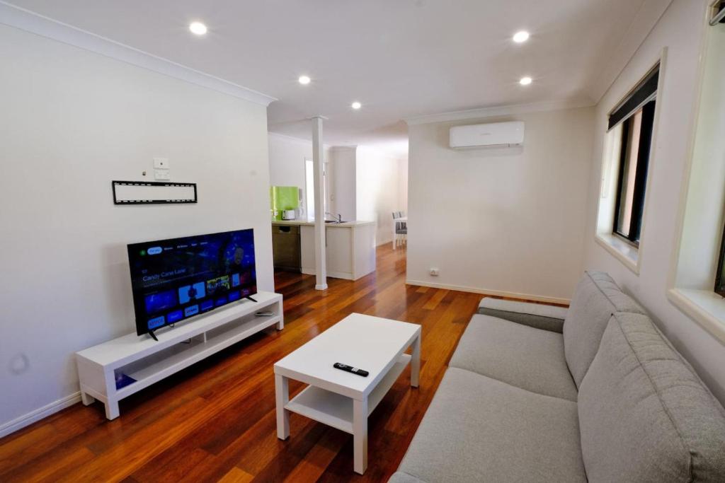 a living room with a couch and a flat screen tv at 2-Bedroom Apt with Terraces in Gold Coast