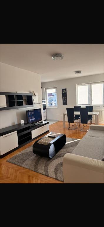 a living room with a couch and a table and chairs at Apartman Centar 1 in Bijeljina