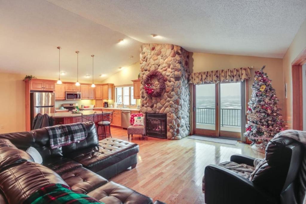 a living room with a couch and a christmas tree at On the lake Hot Tub Pool Table 10 Beds in Cokato