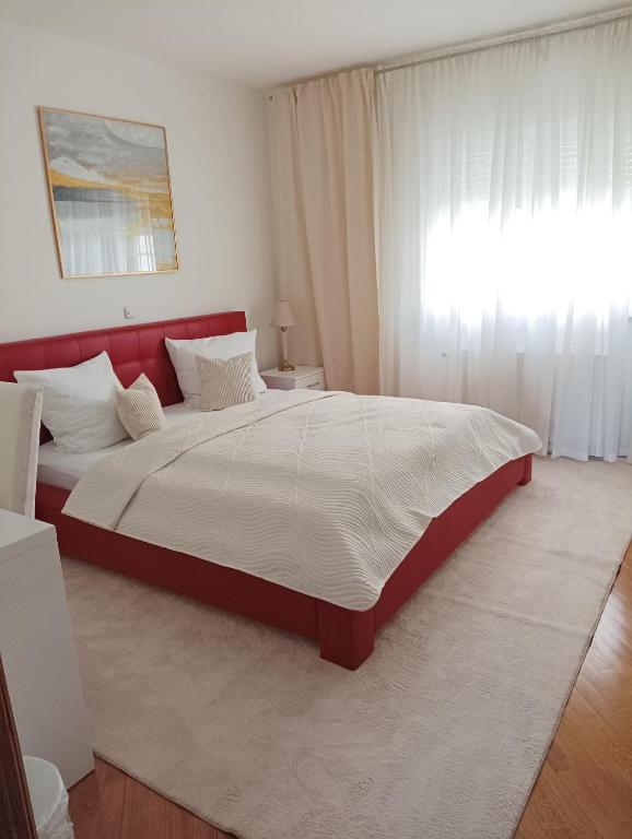 a bedroom with a large bed with a red headboard at Vila Maria II in Vinkovci
