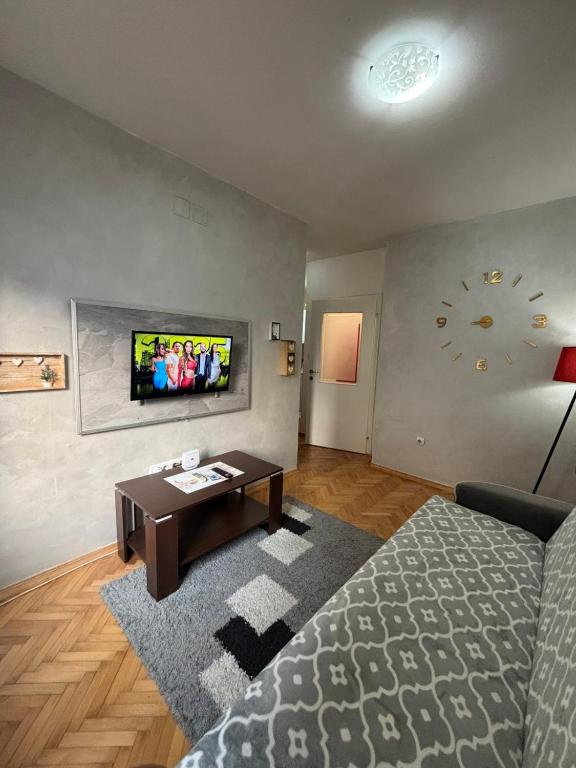 a living room with a bed and a tv on the wall at Apartman kod autobuske in Bijeljina