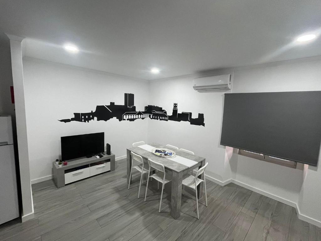 sala de estar con mesa y TV de pantalla plana en Casa do Ferrador, en Moura