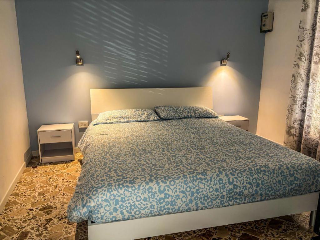 a bedroom with a bed and a blue wall at Il fico d'india in Marsala