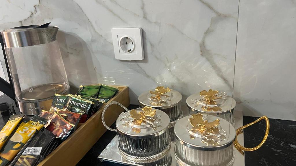 a table with four silver dishes and a lightswitch at Евро двушка in Astana