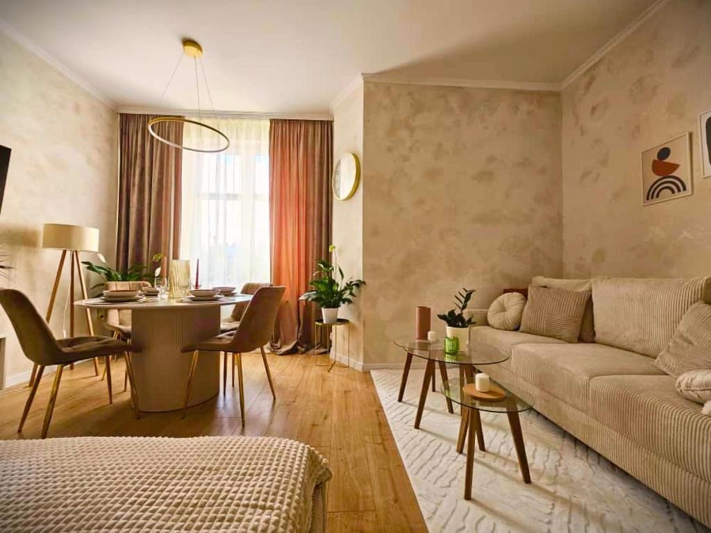 a living room with a couch and a table at Apartamenty Paryskie Old Town View in Toruń