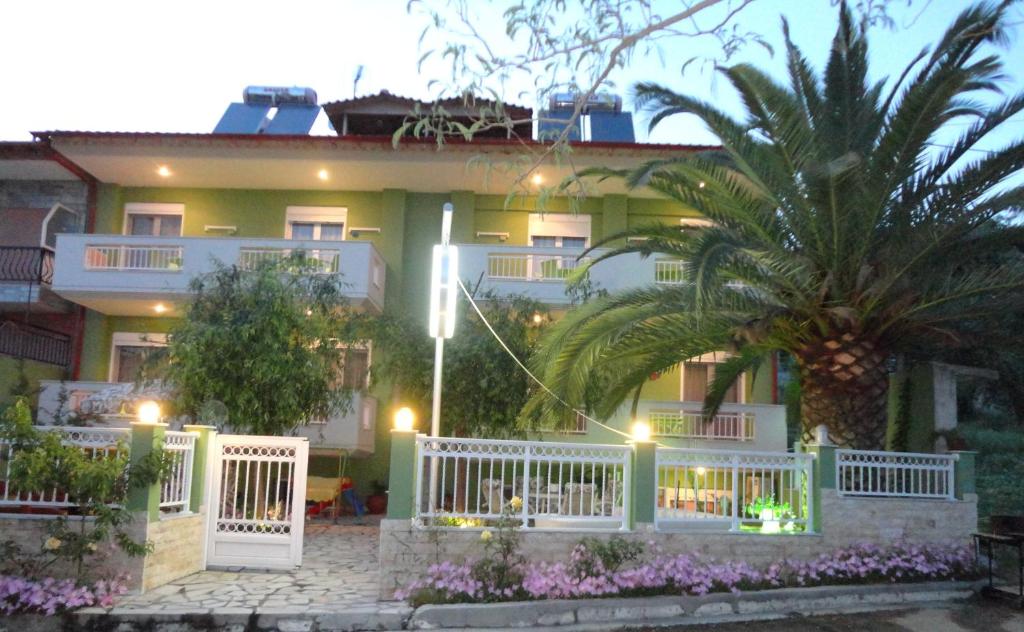 a house with a white fence and a palm tree at Phoenix Studios by Tania in Sarti