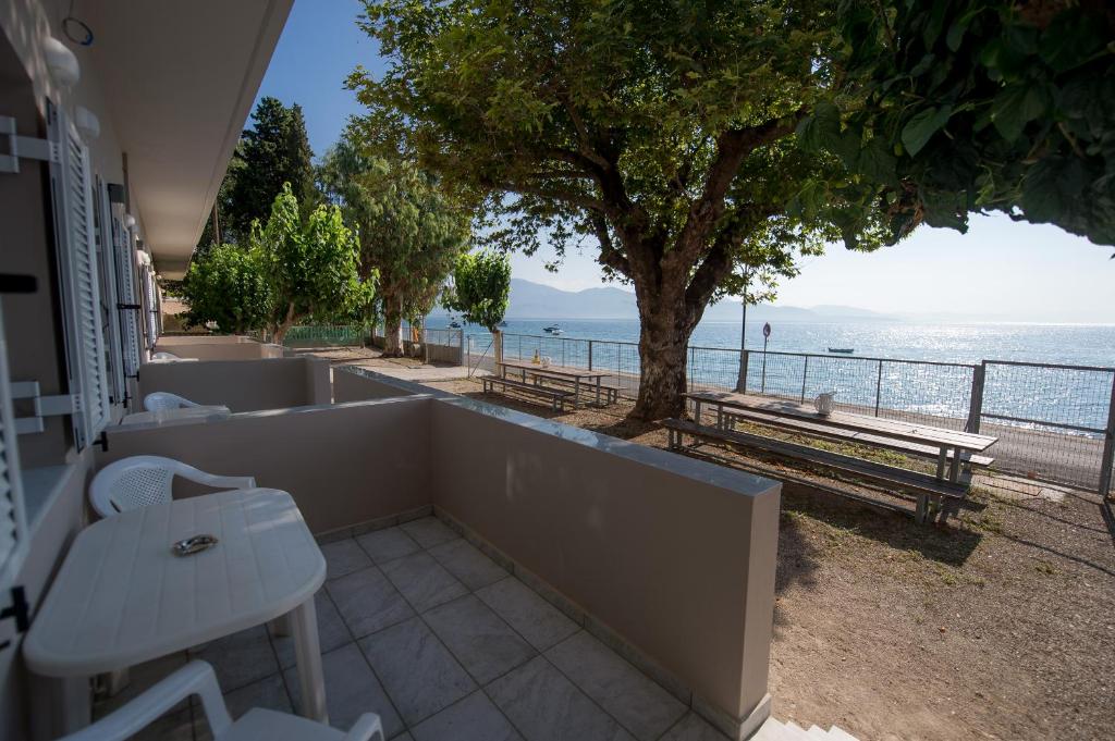 een balkon met een tafel en uitzicht op de oceaan bij Nikolatos Apartments in Longos