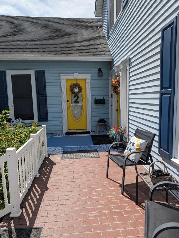 a yellow door on a house with a patio at Cozy, Cute, Private Ozark Suite 5 Mins to Hospital in Ozark