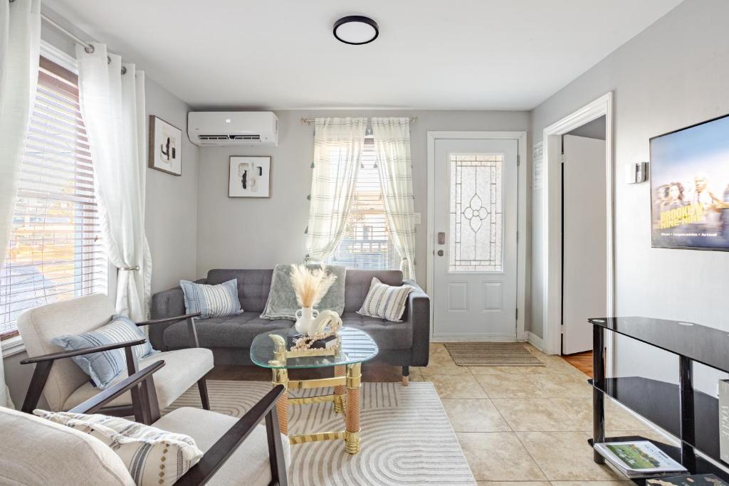 una sala de estar con un sofá y una mesa en Grande maison moderne 4 chambres - Spa Jaccuzi, Jardin & Parking gratuit - Idéale Familles et groupes, en Saint-Jean-sur-Richelieu