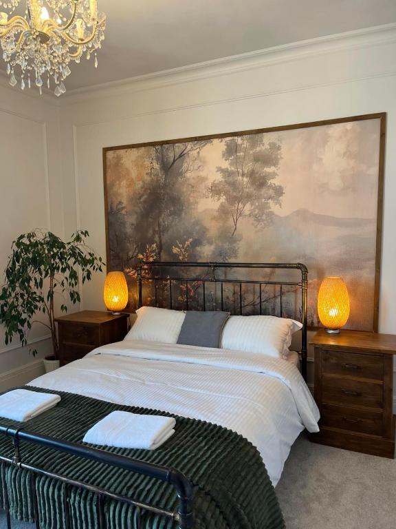 a bedroom with a bed with a painting on the wall at Victorian Inspired Home in Stockport