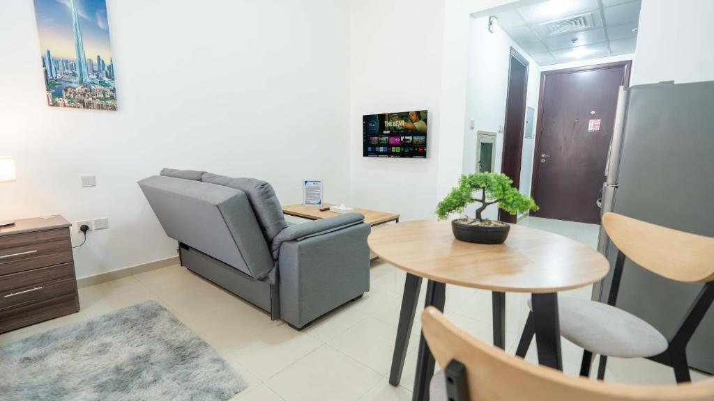 un salon avec une chaise et une table dans l'établissement Village View Serenity by Hala Homes, à Ras al Khaimah