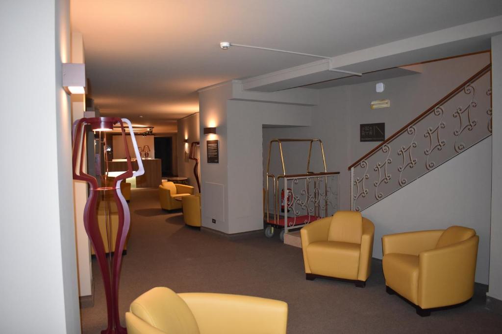 a waiting room with yellow chairs and a staircase at Garibaldi Palace in Milan