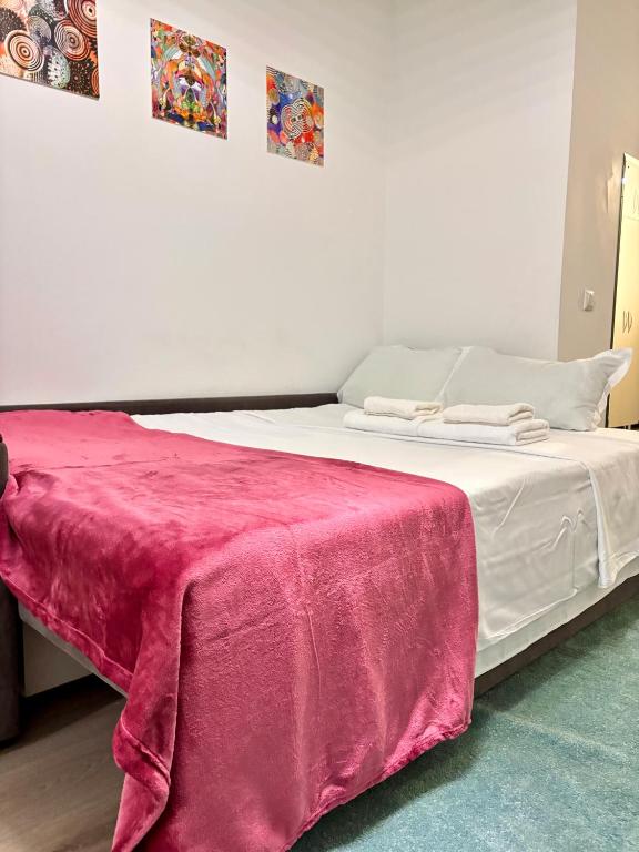 een wit bed met een rode deken erop bij The Palas Retreat in Iaşi