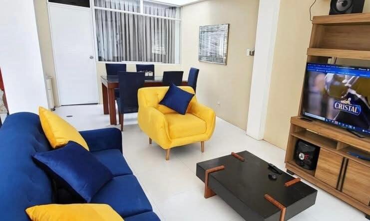 a living room with a blue couch and a tv at Casa Rosé Vacacional in Santa Rosa