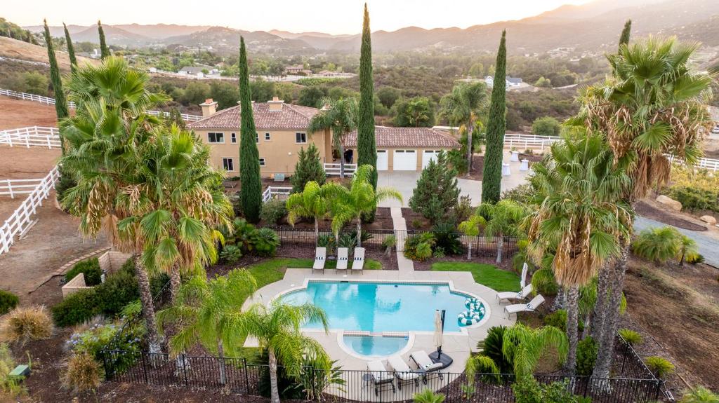 an aerial view of a villa with a swimming pool and palm trees at Villa on 5 Acre Vineyard Equestrian Estate, Pool & Hot tub, Events in Murrieta