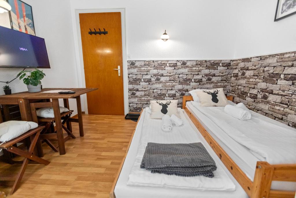 a room with two beds and a desk and a table at Studio 2 pp - Crans-Montana Centre - Rue du Prado in Lens