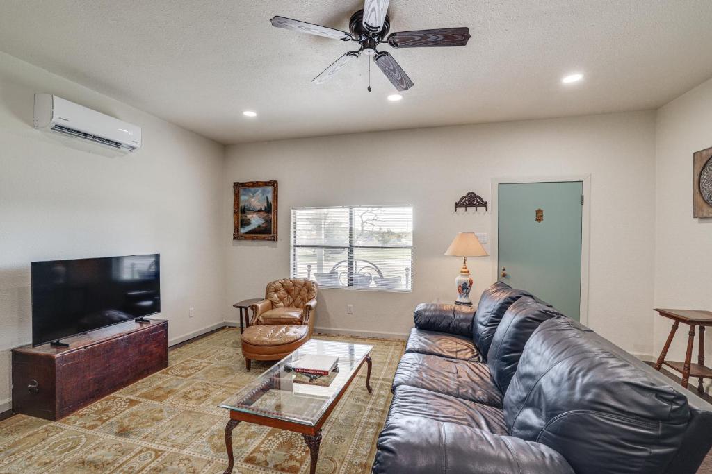sala de estar con sofá de cuero y TV de pantalla plana en Walk to Historic Square Jacksboro Home with Yard, en Jacksboro