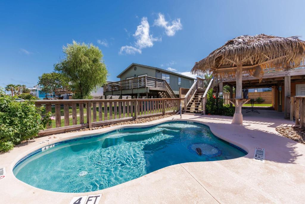 een klein zwembad met een rieten dak bij Someday Isle - 2BDR Home for 6 in Port Aransas