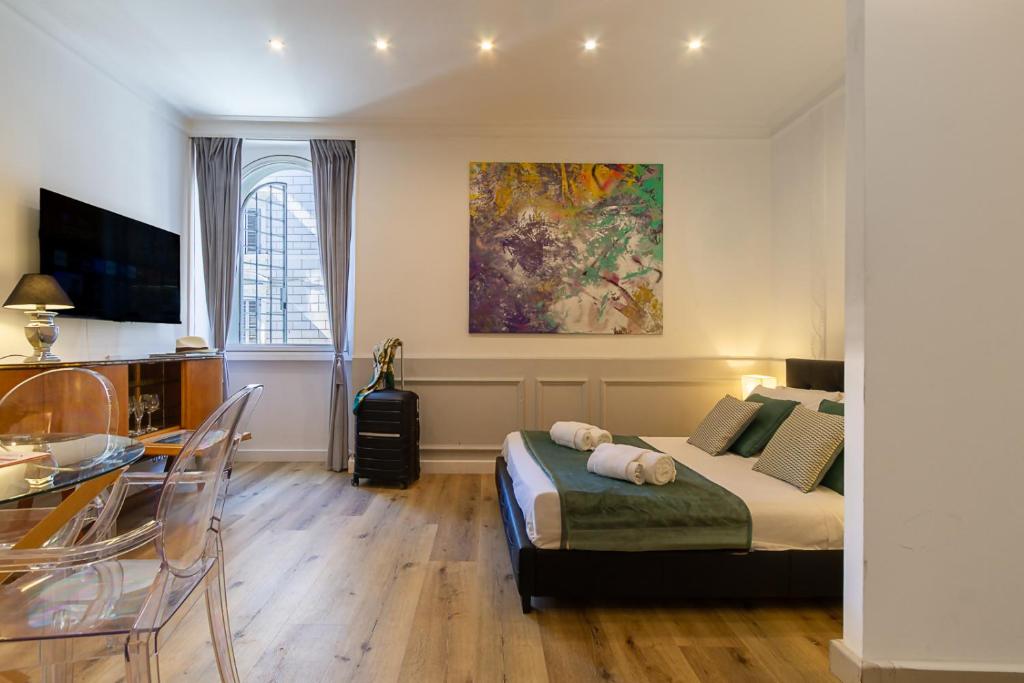 ein Schlafzimmer mit Bett und Tisch und ein Esszimmer in der Unterkunft Crispi 30 Stylish Apartment in Rom