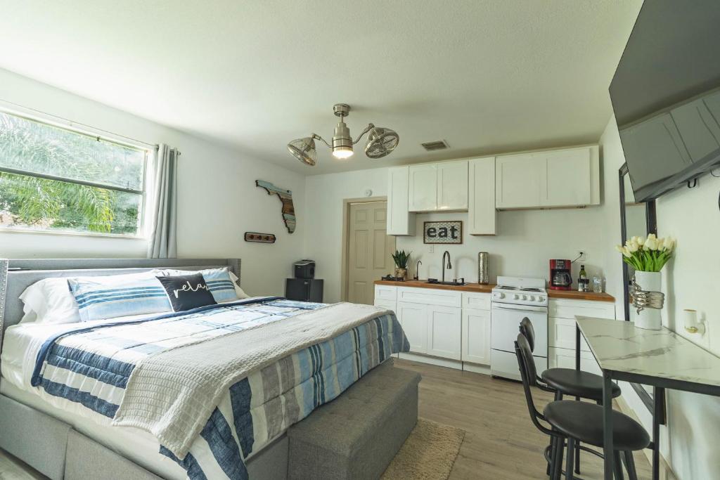a bedroom with a bed and a kitchen with a table at 10 Minutes from Universal - Relaxing Guest Suite in Orlando