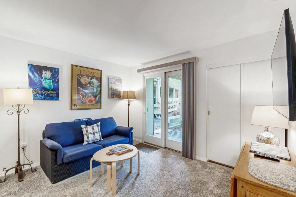a living room with a blue couch and a table at Valley Gem Lower in Elkhorn Village