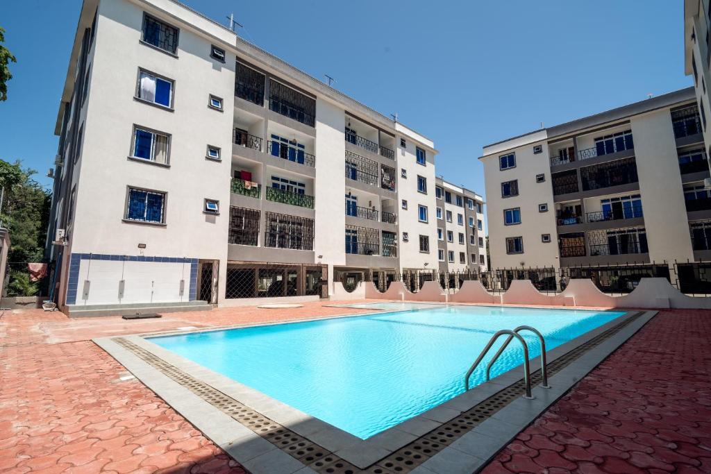 an empty swimming pool in front of two buildings at Marhaba Tausi Nyali in Mombasa