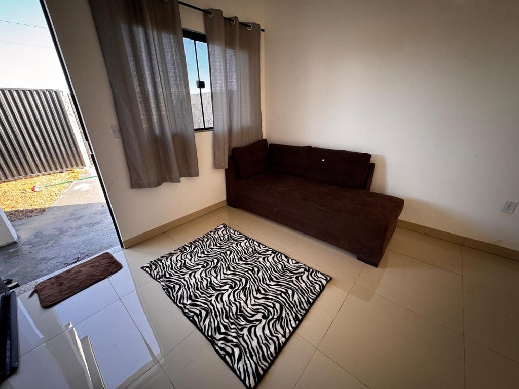a living room with a couch and a zebra rug at Casinha Aconchegante in Primavera do Leste