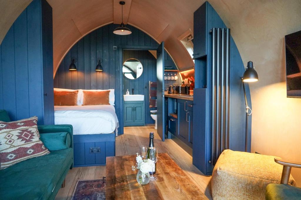 - une chambre avec des murs bleus, un lit et un canapé dans l'établissement Homestead Gardens by Wigwam Holidays, à Filby