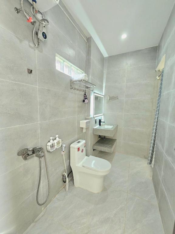 a white bathroom with a toilet and a shower at Hang Camping 2 in An Ninh