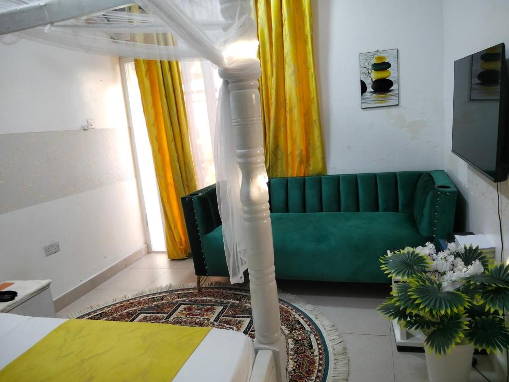 Un dormitorio con una cama y un sofá verde. en Bnb, en Mombasa