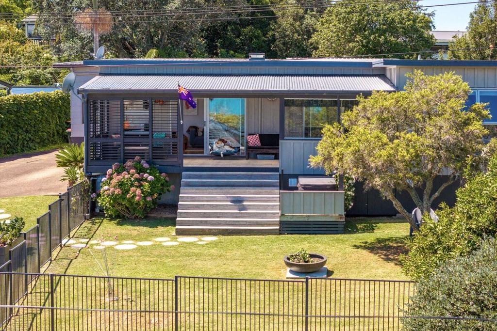 a house with a flag on the front of it at Waters Edge by Waiheke Pure in Waiheke Island