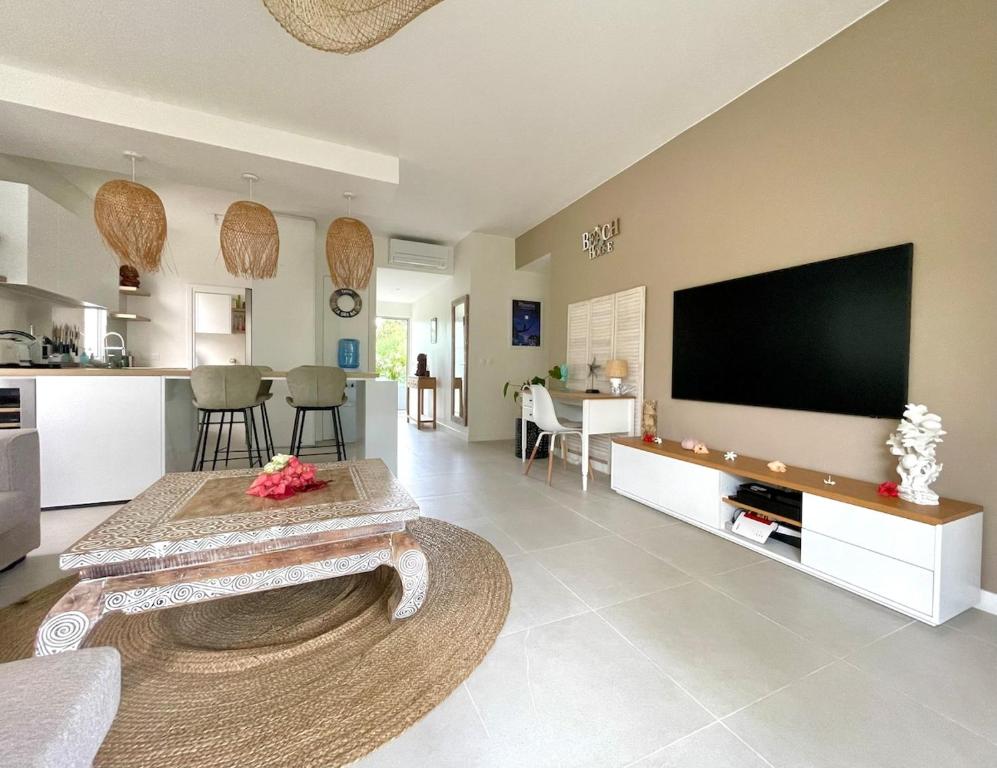 a large living room with a large flat screen tv at Tahiti Beach Loft - Pool - private beach access in Paea