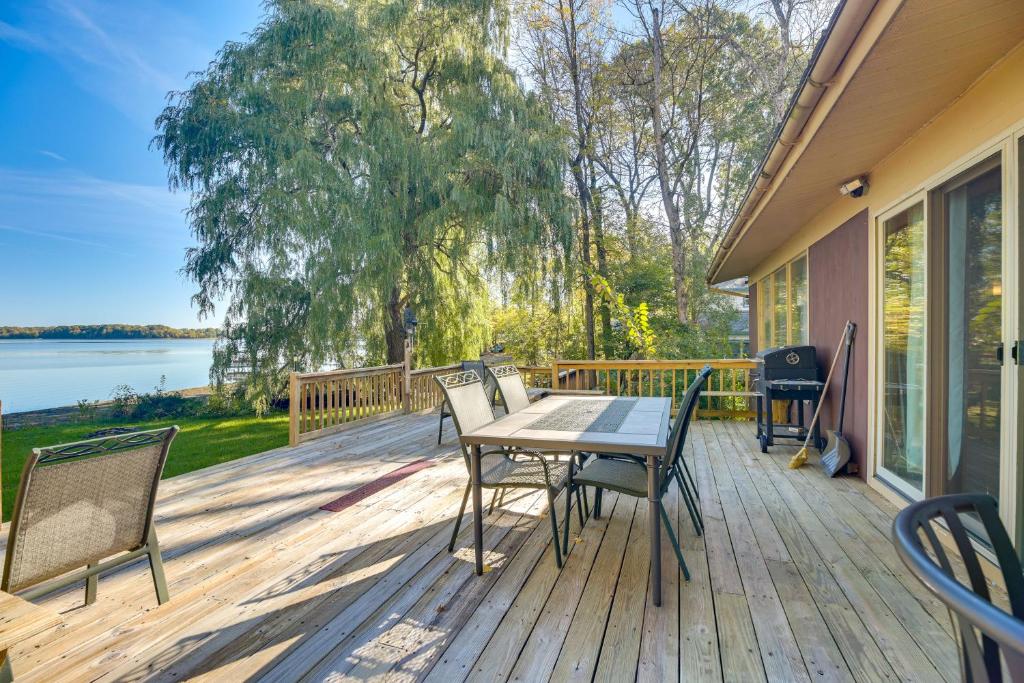 a wooden deck with a table and chairs on it at Lakefront Escape: Waterfront Lake Champlain Home in North Hero