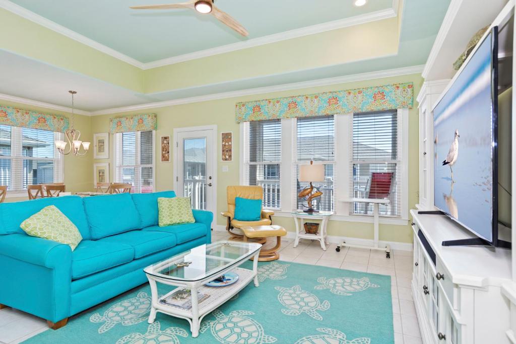 a living room with a blue couch and a tv at Ocean Club J-301 in Indian Beach