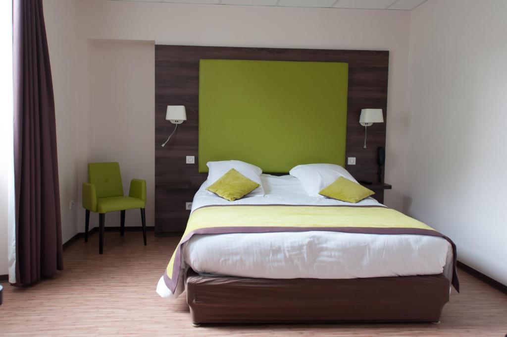 ロン・ル・ソーニエにあるLogis Hotel du Parc-Restaurant - Le Rouget de Lisleの緑の壁のベッドルーム1室(大型ベッド1台付)