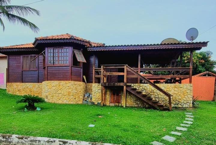 a house with a staircase in front of it at Casa de Madeira com piscina e churrasqueira in Araruama