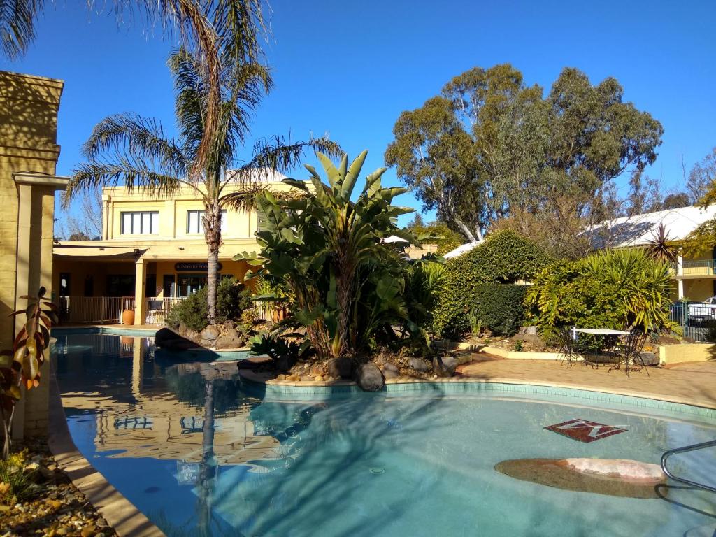 a large swimming pool in front of a house at Madison Spa Motel - Adults Only in Moama