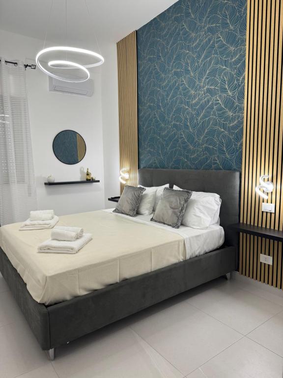 a bedroom with a large bed with a blue wall at Sasi Home in Terrasini