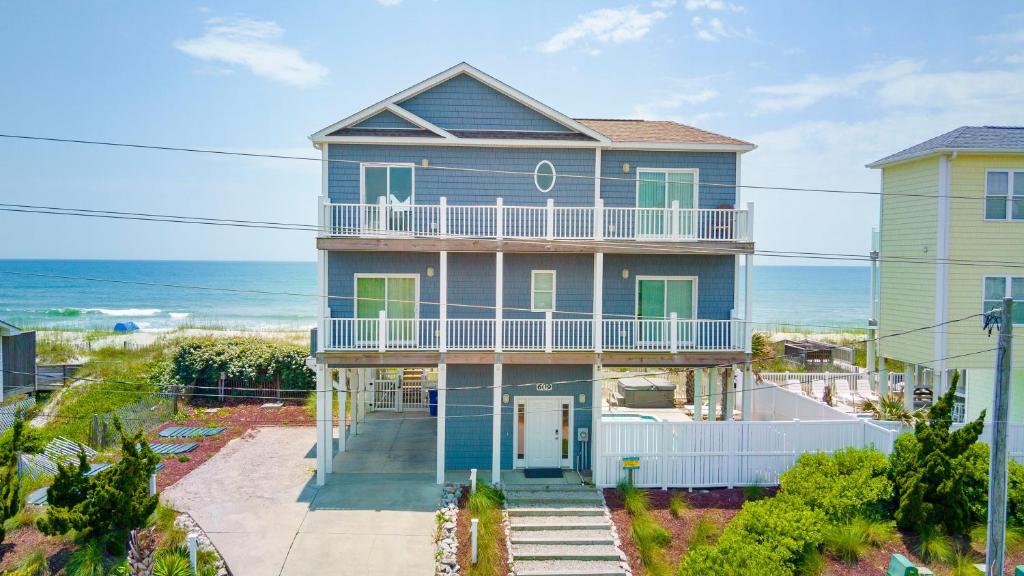 a blue house with a balcony and the ocean at Sea Worthy in Indian Beach