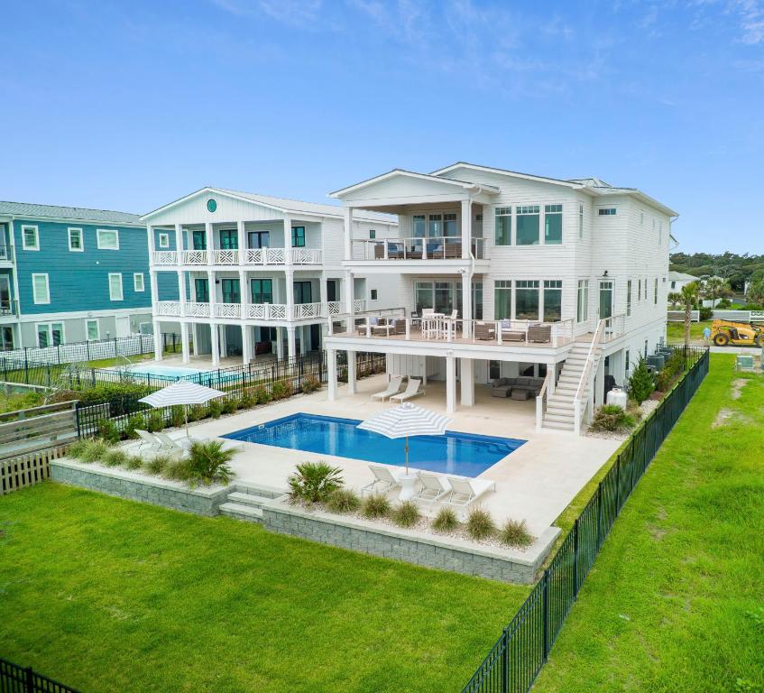 an aerial view of a large white house with a swimming pool at Roosevelt Oceanfront Escape by Emerald Isle Realty in Pine Knoll Shores
