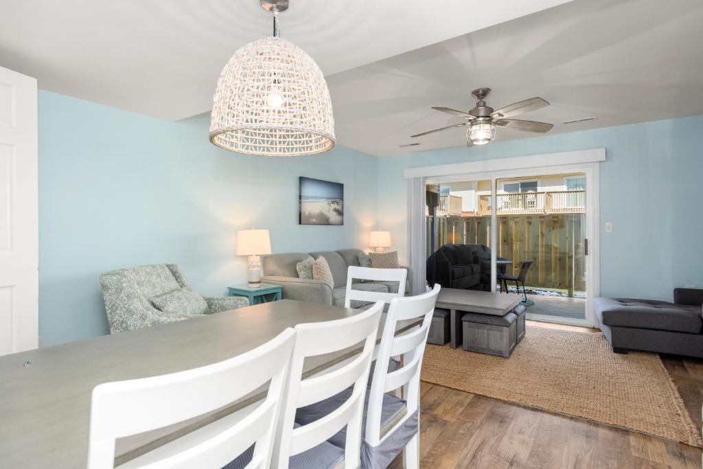 a dining room and living room with a table and chairs at Pine Knoll Townes 126 by Emerald Isle Realty in Pine Knoll Shores