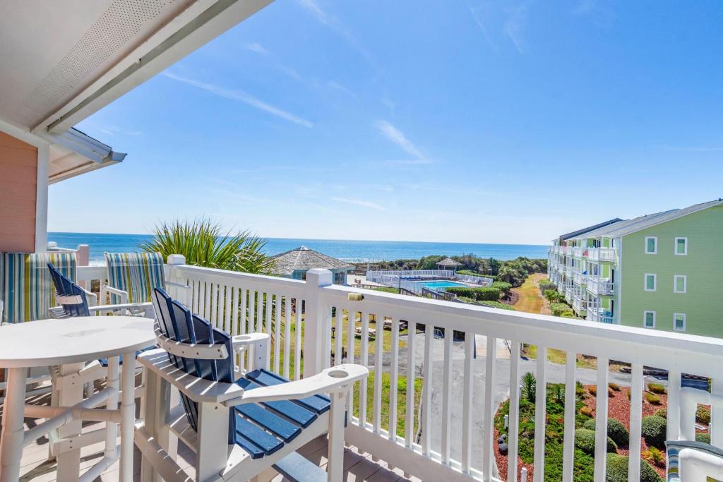 a balcony with chairs and a table and the ocean at Pebble Beach D302 in Cedar Point