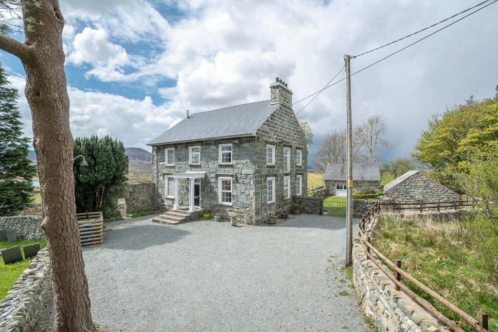 una antigua casa de piedra con una gran entrada en Rheithordy, en Trawsfynydd
