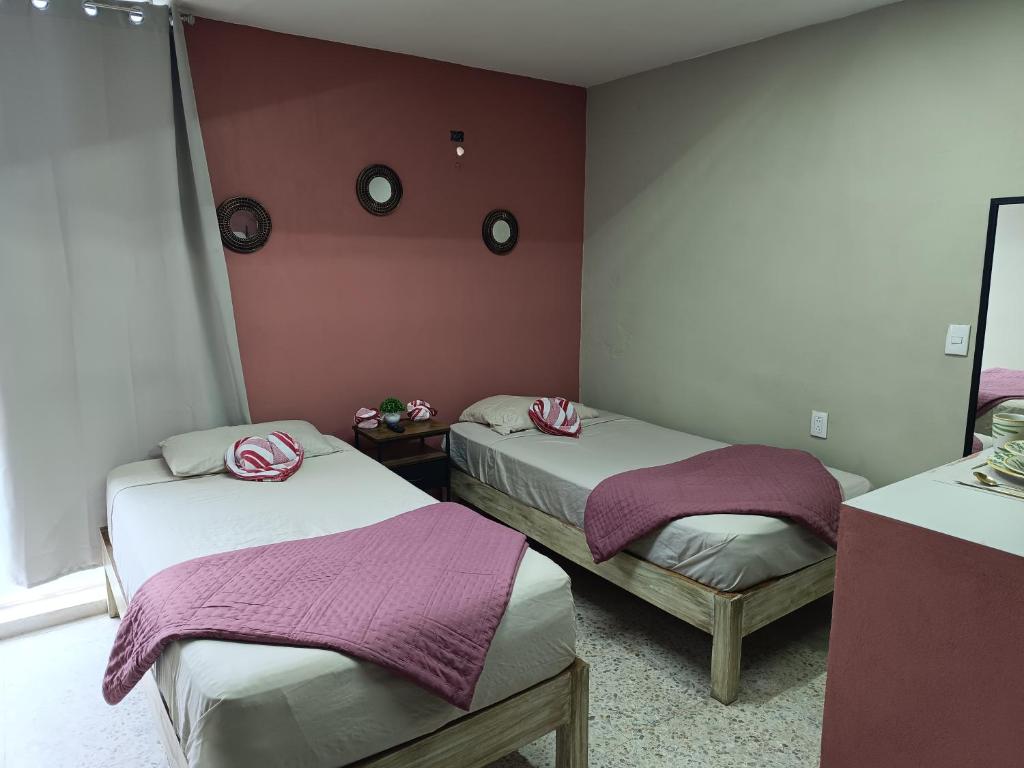 two beds in a room with purple walls at Suite 102 Cordoba Centro Estacionamiento in Córdoba