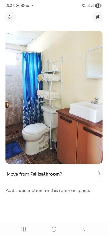 a bathroom with a toilet and a sink at Purple House in Puerto Armuelles
