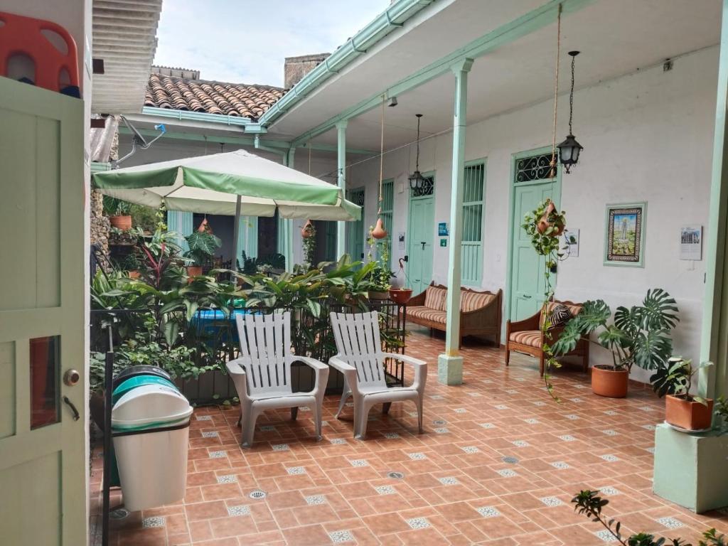 a patio with two chairs and an umbrella at Sandalio Hostal Cali in Cali