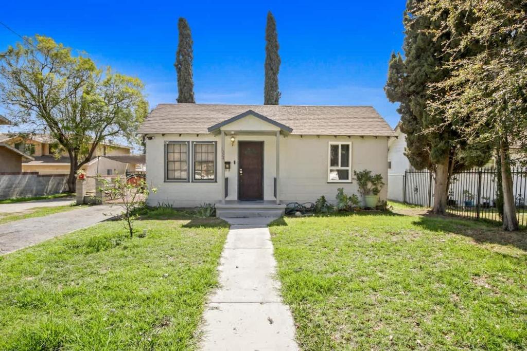 a white house with a door in a yard at 2BR Pet-Friendly Home # RV FREE in Upland