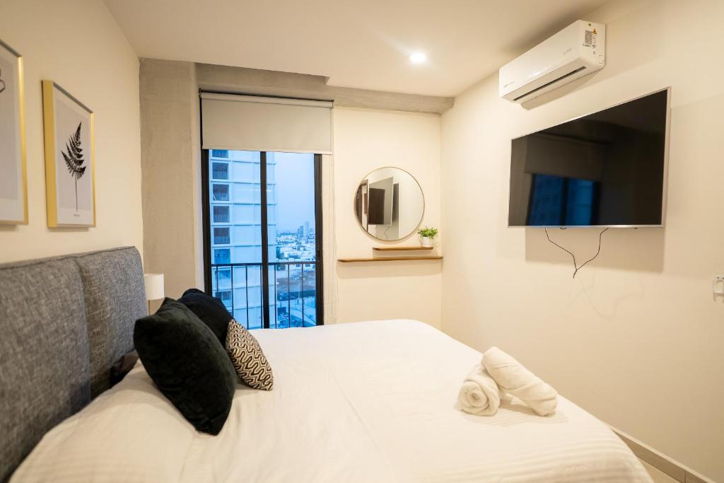 グアダラハラにあるNuevo Departamento Céntrico con Alberca y Parkingのベッドルーム1室(ベッド1台、テレビ、窓付)