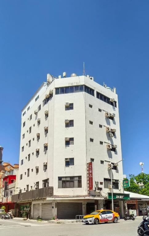 a building with a yellow car parked in front of it at 又一宿-又上的臨時客棧 in Taitung City