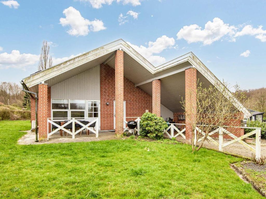 a brick house with a dog sitting in front of it at Cozy Retreat near Beach - By Traum Ferienwohnungen in Børkop